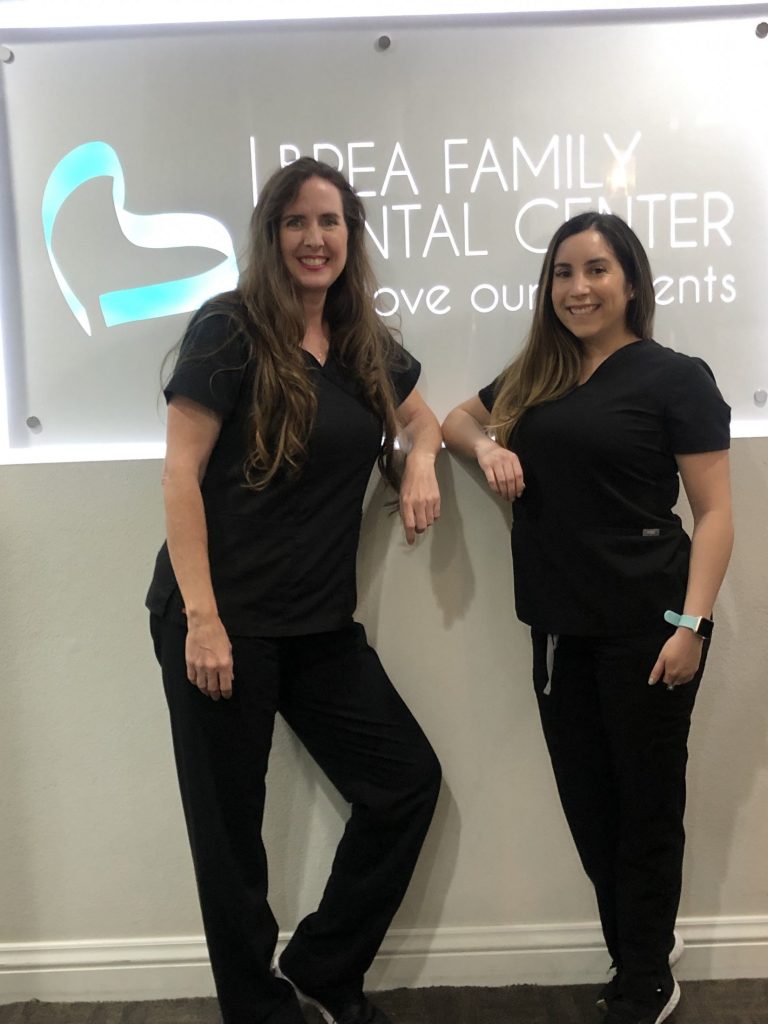 the two hygienists posing in front of the logo